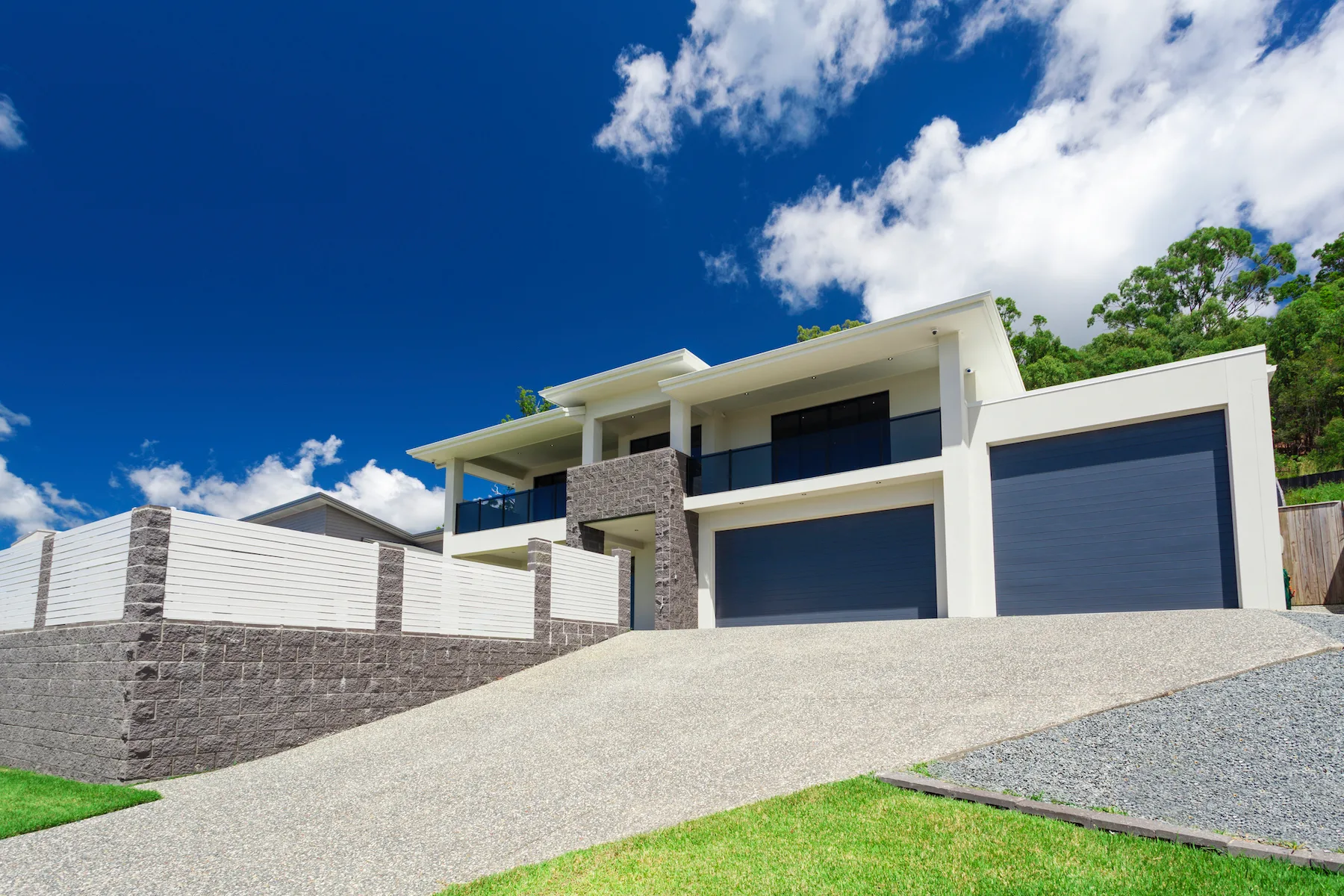 Sloped concrete driveway leading to a two-storey home