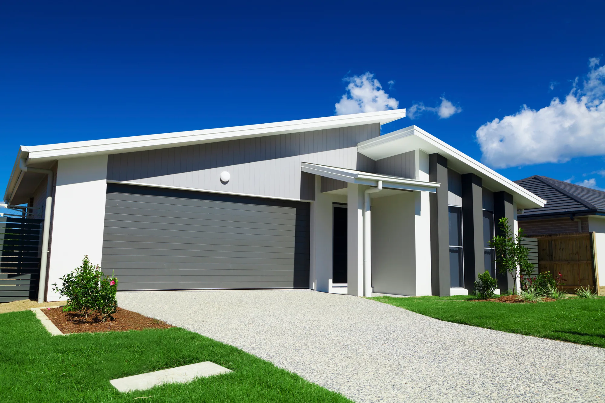 Exposed aggregate concrete driveway finished in front of a modern home